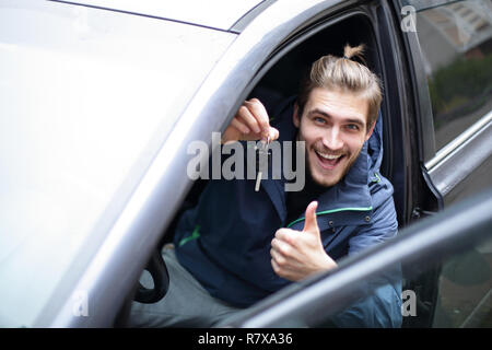 Glückliche junge Mann in seinem neuen Auto. Stockfoto