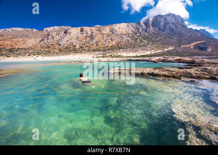 Jungen attraktiven Mann Schwimmen in Balos Lagune auf der Insel Kreta mit azurblauen Wasser, Griechenland, Europa. Kreta ist die größte und bevölkerungsreichste der Gr Stockfoto