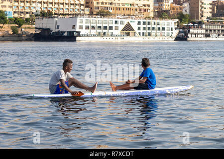 Assuan, Ägypten - September 13, 2018: Ägyptische Kinder in einem Surf Board im Nil. Stockfoto