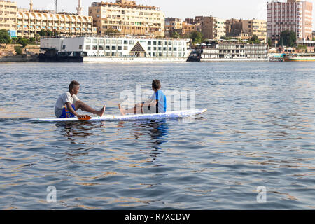 Assuan, Ägypten - September 13, 2018: Ägyptische Kinder in einem Surf Board im Nil. Stockfoto