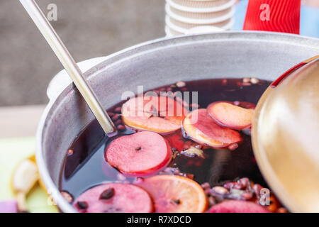 Glühwein im Bügeleisen Topf im city street fair vorbereitet. Traditionelle Weihnachten und neues Jahr Alkohol trinken - Glühwein. Mit Getränken in der Stadt Stall im Winter Stockfoto