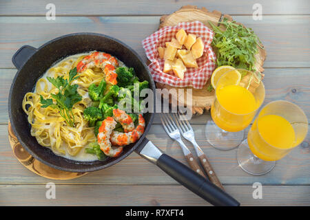Vollkorn Nudeln mit Garnelen und Käse auf Holztisch, Ansicht von oben Stockfoto