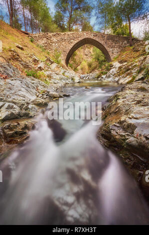 Mittelalterlichen venezianischen Brücke in die Schlucht zwischen den Felsen am sonnigen Frühling Abend. Zypern Brücke Elia. Stockfoto