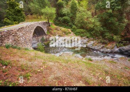 Mittelalterlichen venezianischen Brücke in die Schlucht zwischen den Felsen am sonnigen Frühling Abend. Zypern Brücke Elia. Stockfoto