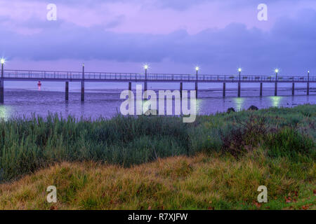 Ishing Stangen an einer Pier durch den Fluss Tejo im Parque das Nacoes - Vasco da Gama Brücke im Hintergrund (Lissabon, Portugal) Stockfoto