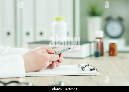 Arzt sie ihr Smartphone in der Arztpraxis, in der Nähe der Hände Stockfoto