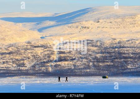 Schweden, Lappland, Region als Weltkulturerbe von der UNESCO, Norrbottens Län, Blick auf Skifahrer gelistet bei Sonnenaufgang am Lake Tornetrask in der Nähe von Abisko Nationalpark Stockfoto