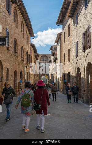 Vertikale Ansicht von Touristen im Tor von San Gimignano, Italien. Stockfoto