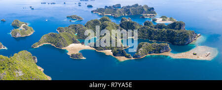 Flachen Korallenriffen umgeben remote Kalkstein Inseln in Raja Ampat, Indonesien. Diese artenreichen Region wird als das "Herz der Korallen Dreieck bekannt." Stockfoto