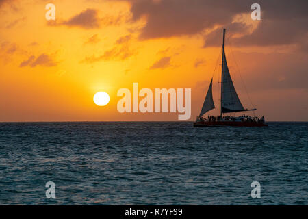 Segelboot bei Sonnenuntergang auf der Insel Aruba - Karibik Booze Cruise Ship Segeln Ausflug - Partygänger auf der niederländischen Insel/Leeward Antillen/Kleine Antillen Stockfoto