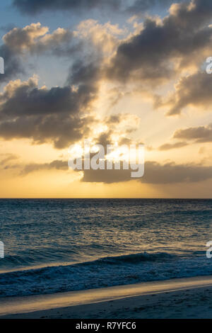 Sonnenuntergang auf Divi Strand Aruba - ziemlich Wellen reflektieren die Sonne - tropischen Strand Sonnenuntergang in der Nähe von Oranjestad Stockfoto