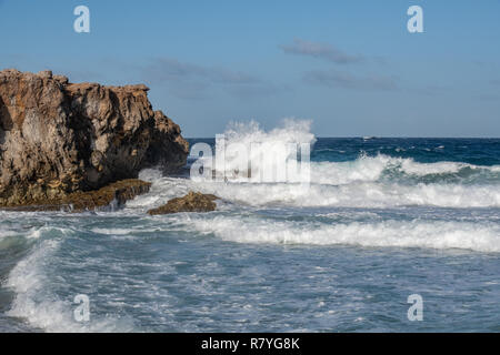 Wellen, die in einen Felsen - Aquamarin und blauen Wellen, die in die Felsen an der Küste von Aruba-Dos Playa Strand im Nationalpark "Arikok" Stockfoto