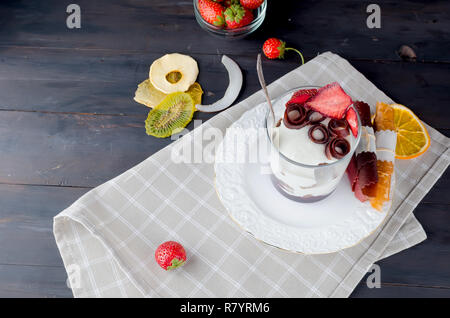 Schokolade Cookies, Sahne und Erdbeeren Nachtisch in einem Glas auf einem darkbackground, leckere Kleinigkeit, Kopie Raum Stockfoto