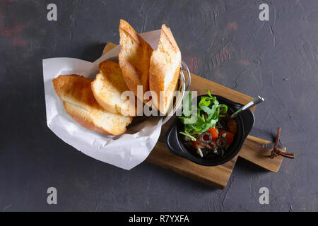 Knusprige Toasts mit Tomaten, Oliven, Rucola und Käse Stockfoto