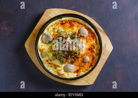 Vegetarisches Omelett mit Champignons in gusseisernen Pfanne Stockfoto