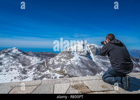 Touristen, die Bilder von der atemberaubenden Bergblick Winterlandschaft Panorama von Stirovnik Peak, der höchste Gipfel der Nationalpark Lovcen, Monten Stockfoto