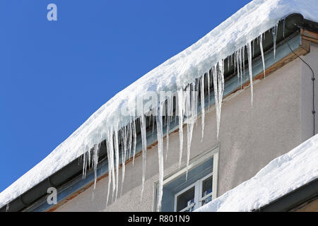 Eiszapfen auf dem Regen Leitung eines Hauses in der Schweiz Stockfoto