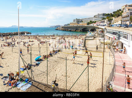 Menschen Volleyball spielen, Sonnenbaden und Schwimmen auf der Prophet Strand in Marseille, einem sehr beliebten Strand auf dem Kennedy Corniche entfernt. Stockfoto