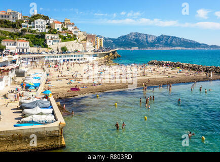 Menschen mit Sonnenbaden und Schwimmen auf der Prophet Strand in Marseille, einem sehr beliebten Strand auf dem Kennedy Corniche entfernt, an einem sonnigen Frühlingstag. Stockfoto