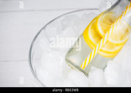 Limonade trinken in trendigen Flasche mit Stroh auf Eis. Kopieren auf der linken Seite. Bündel Zitronenscheiben. Stockfoto