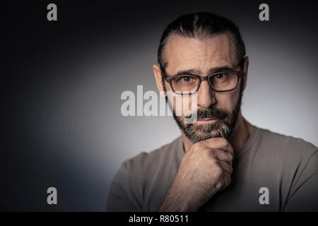 Porträt der Mann mit langen Haaren und Brille studio Shot denken Position Stockfoto