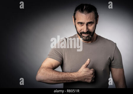 Lange Haare Mann Daumen up Studio shot Stockfoto
