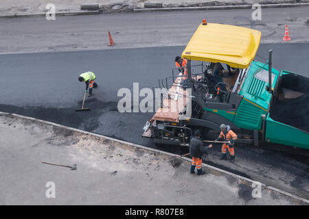 Asphalt fertiger Maschine oder fertiger Finisher Orte eine Schicht von frischem Asphalt. Straße Erneuerung. Straßenbau arbeiten. Hohe Betrachtungswinkel Stockfoto