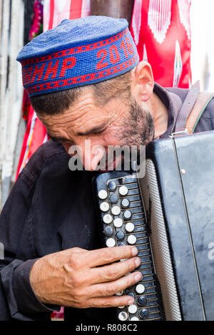 Khorog, Tadschikistan, 20. August 2018: Ein alter Musiker spielt auf dem Basar in Khorog auf seinem Akkordeon Stockfoto