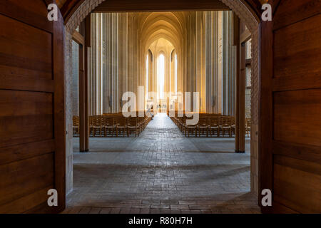 Kopenhagen, Dänemark - 18 September 2018: Innenraum der Grundtvigs Kirche (Kirke) mit gemauerten Säulen, Sonnenlicht, Stühle und den Menschen in der Kirche sitzen Stockfoto