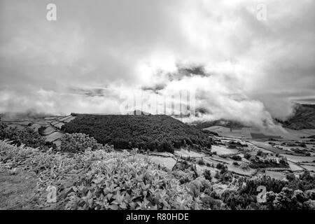 Schwarze und weiße Blick auf die dramatische Wolken über die Caldera von Alferes in der Nähe von Sete Cidades in Sao Miguel. Stockfoto