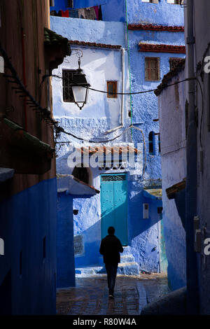 Marokko, Fes, Medina Silhouette des Mannes an der Kreuzung von nassen schmalen Straßen der Altstadt Stockfoto