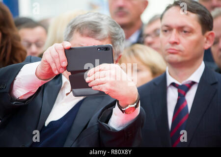 Belarus ist die Stadt Gomel am 25. Oktober 2018. Ausstellung für Produkte der nationalen Wirtschaft. Ältere Mann nimmt selfie Stockfoto