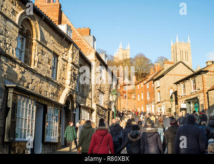 Massen von Menschen klettern steilen Hügel am Lincoln Weihnachtsmarkt, Lincolnshire, England, Großbritannien Stockfoto