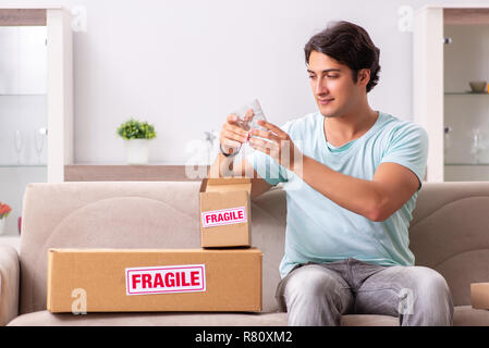 Mann öffnen zerbrechliches Paket aus dem Internet bestellt Stockfoto