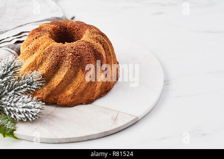 Vanille und Schokolade Marmor bundt Cake auf Marmor Servierteller über weißem Marmor Tisch mit Platz für Text kopieren. Stockfoto