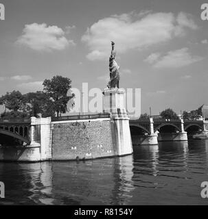 1950 s, historischen, einen Blick auf die Nachbildung der Freiheitsstatue stehen fast 38 Meter hoch auf einer künstlichen Insel im Fluss Seine in Ile aux Cygnes von Grenelle Brücke, im Jahre 1889 vorgestellt worden, das centennial der Französischen Revolution zu gedenken. Stockfoto