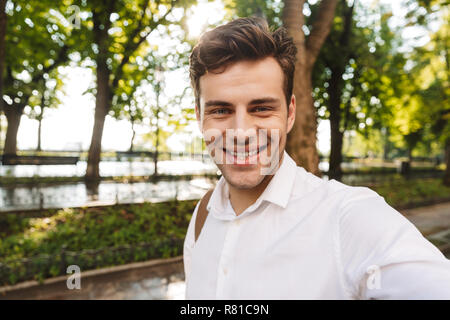 Glückliche junge Unternehmer tragen Shirt ein selfie beim Stehen im Freien im City Park Stockfoto