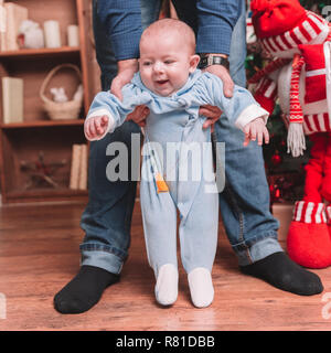 Bis zu schließen. Der Vater seinem Sohn hilft, die ersten Schritte zu machen Stockfoto