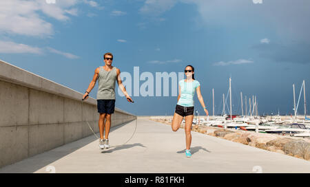 Glückliches Paar Aufwärmen am Pier vor dem Training Stockfoto