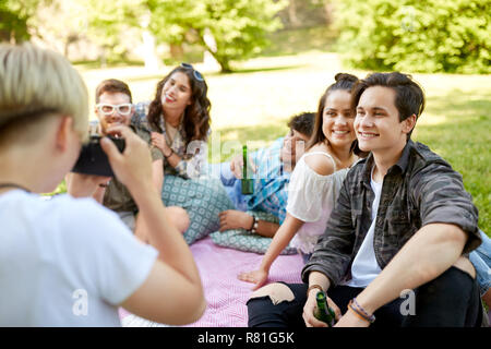 Freunde mit Getränken fotografieren im Sommer Picknick Stockfoto