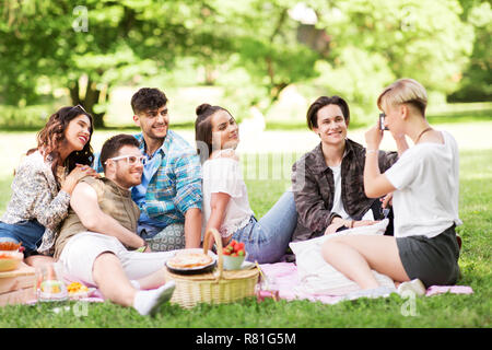 Freunde fotografieren im Sommer Picknick im Park Stockfoto