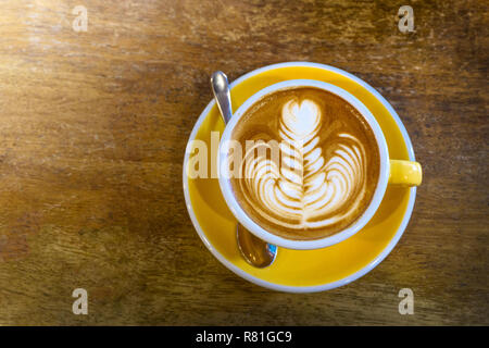 Kaffee in gelb Tasse Kaffee und auf einem Holz Hintergrund. Stockfoto