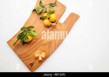 Frisch gepflückt Mandarinen auf Holzbrett. Mandarin Orangen, Mandarinen auf Schneidebrett. Ernährung, gesunde Lebensweise, gesunde Ernährung Konzept. Winter Früchte. Zitrusfrüchte, Vitamin C Stockfoto