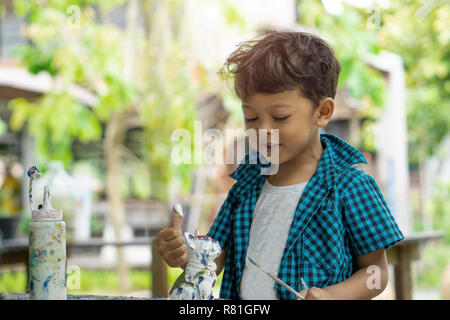 Asiatische Kinder genießen seine Malerei mit den Händen. Stockfoto