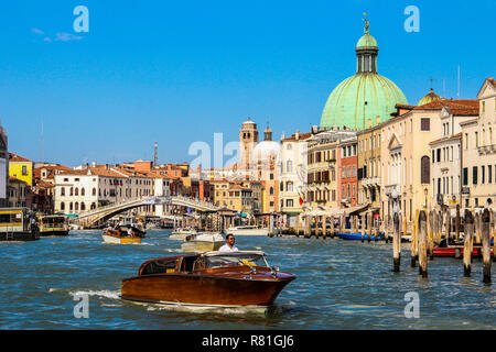 Segeln auf einer hölzernen Boot durch Venedig an einem hellen Tag mit einem klaren blauen Himmel. Stockfoto