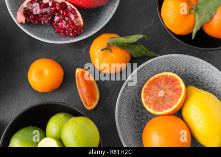 Aus der Nähe von Zitrusfrüchten in Schalen Früchte auf steinernen Tisch Stockfoto