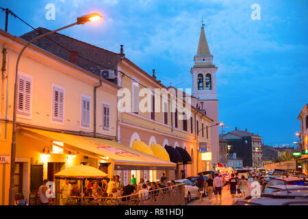 NOVIGRAD, KROATIEN - 20. AUGUST 2017: Leute an einem Street Restaurant bei Dämmerung in Novigrad. Novigrad ist Touristen beliebten Badeort in Croati Stockfoto