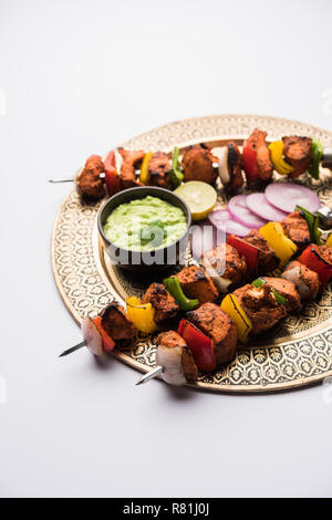 Chicken Tikka/skew Kebab. Traditionelle indische Gericht gekocht auf Holzkohle und Flamme, gewürzt & bunt garniert. Mit grüner Chutney und Salat serviert. Stockfoto