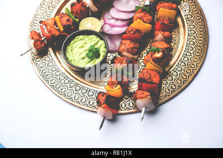 Chicken Tikka/skew Kebab. Traditionelle indische Gericht gekocht auf Holzkohle und Flamme, gewürzt & bunt garniert. Mit grüner Chutney und Salat serviert. Stockfoto