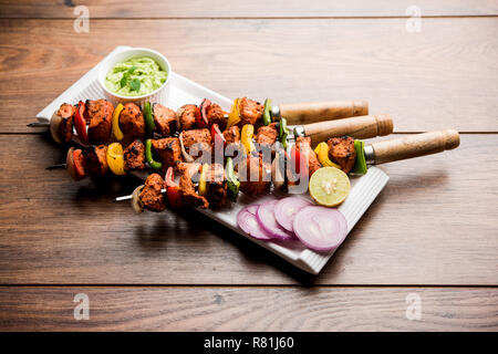 Chicken Tikka/skew Kebab. Traditionelle indische Gericht gekocht auf Holzkohle und Flamme, gewürzt & bunt garniert. Mit grüner Chutney und Salat serviert. Stockfoto